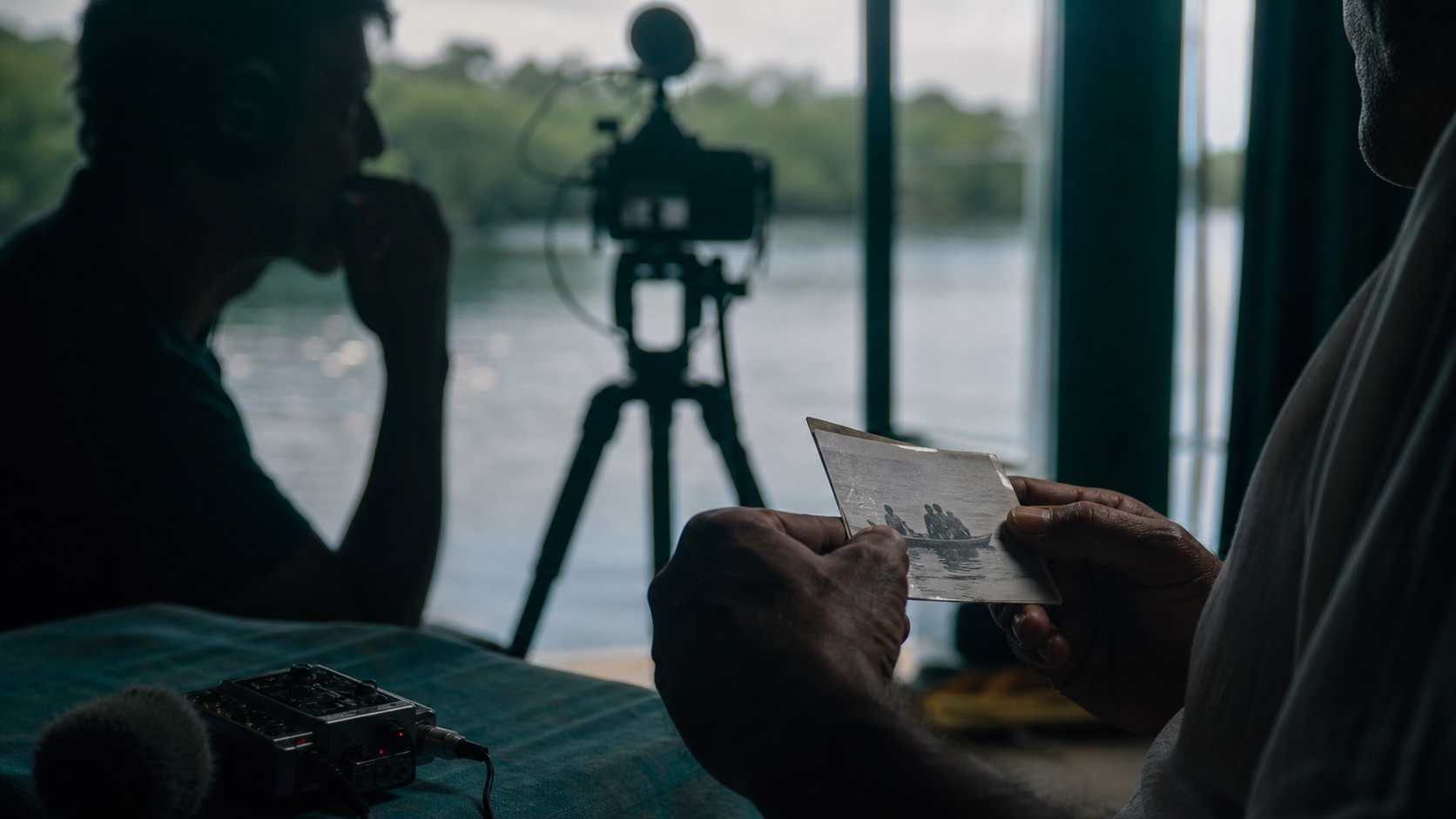Narrativa documental com entrevista em silhueta, câmera, água ao fundo e memória nas mãos.